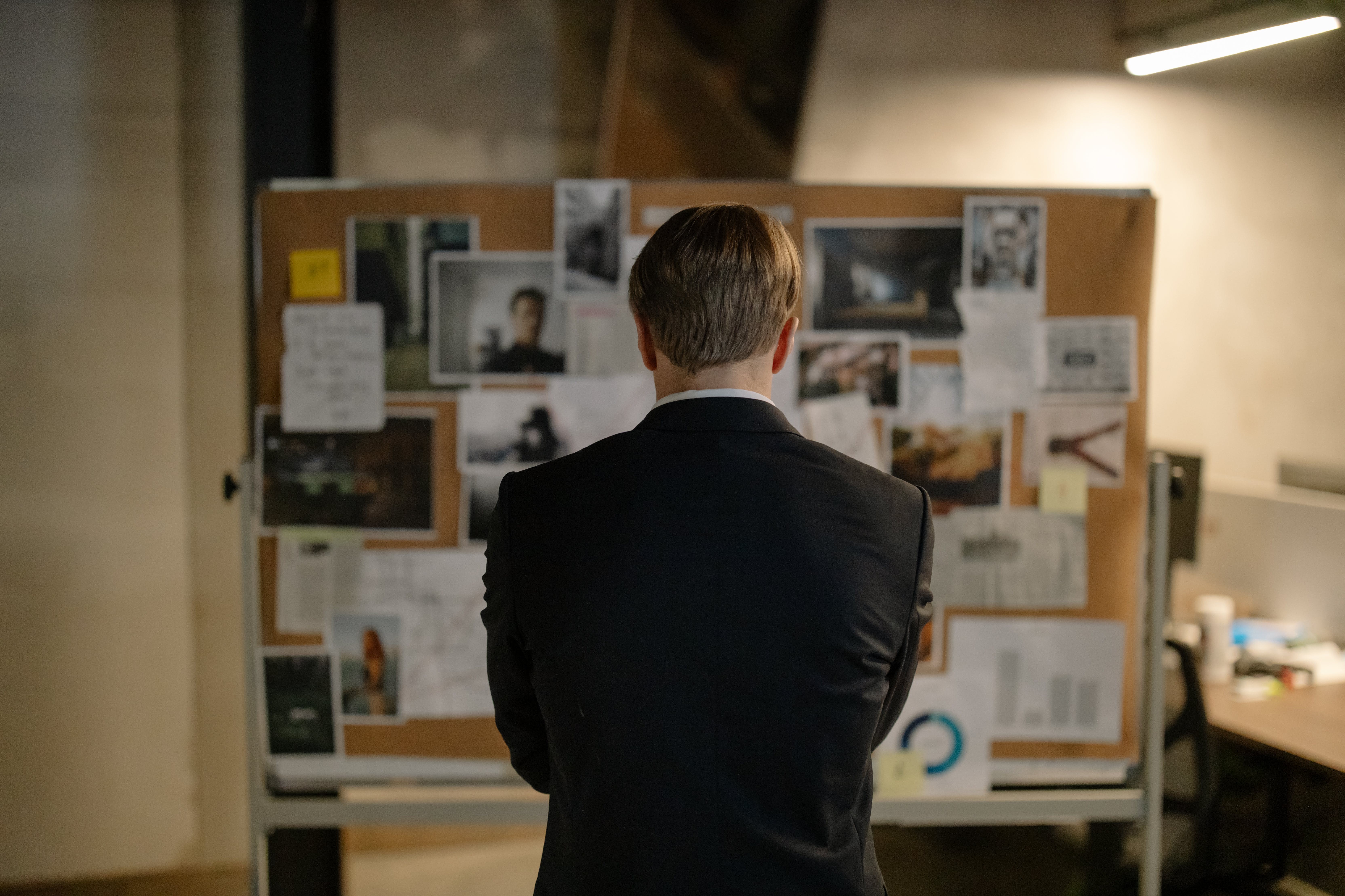 criminal defense private investigator studies a bulletin board